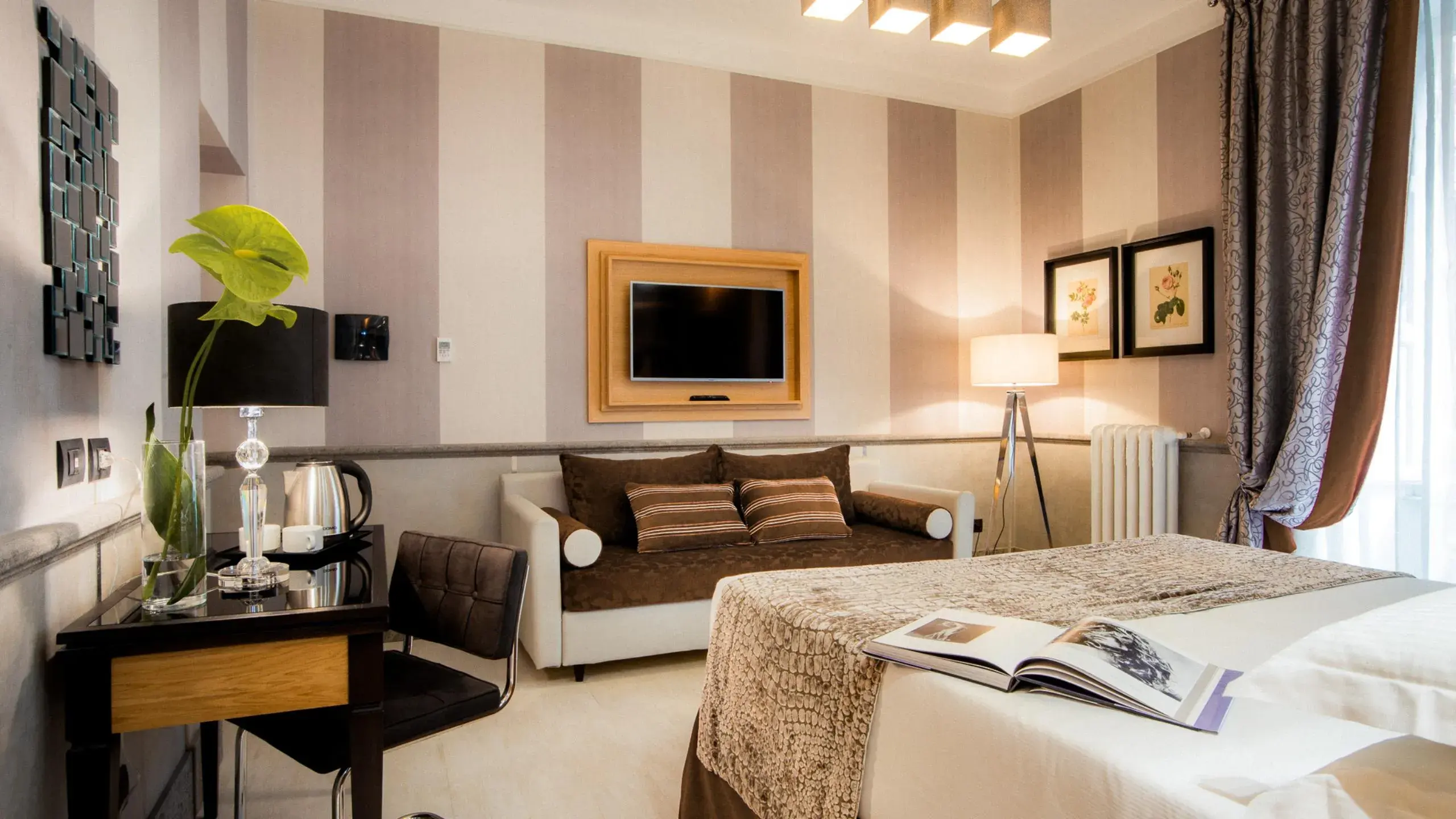A room with a sofa, a tripod lamp and a book left open on the bed