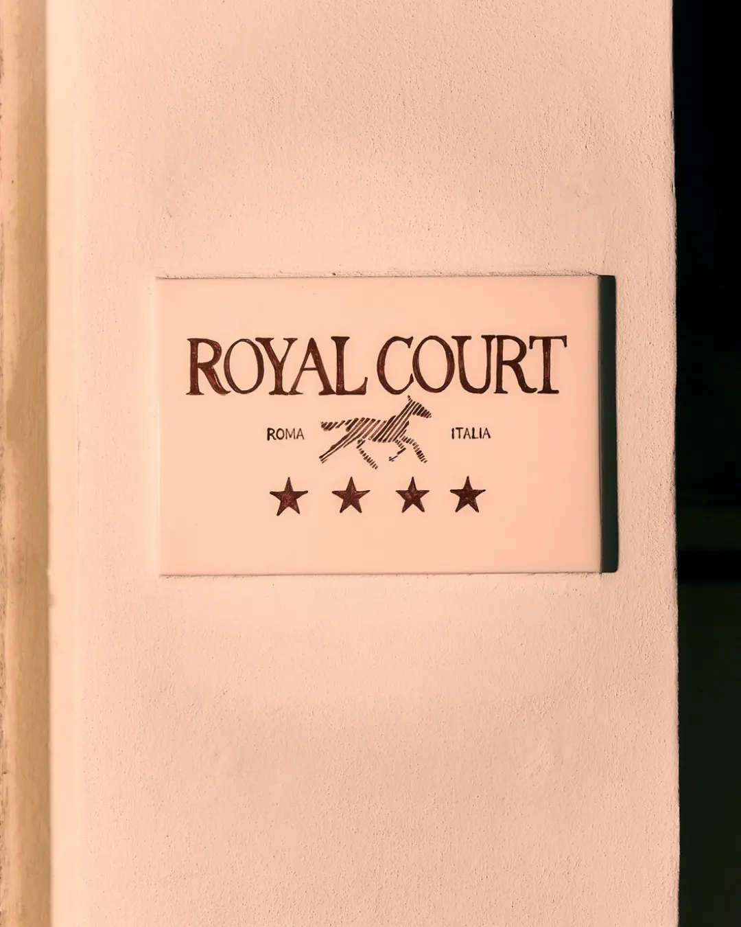 The Royal Court plaque beside the door, four stars beneath the running horse