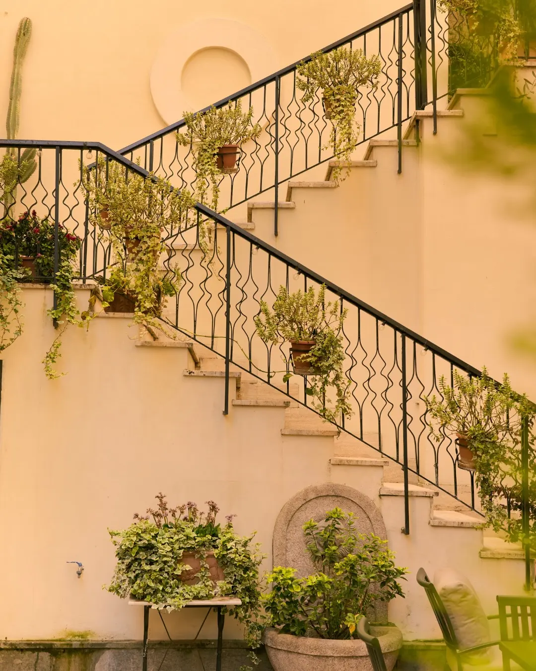 The courtyard staircase, potted plants on every tread