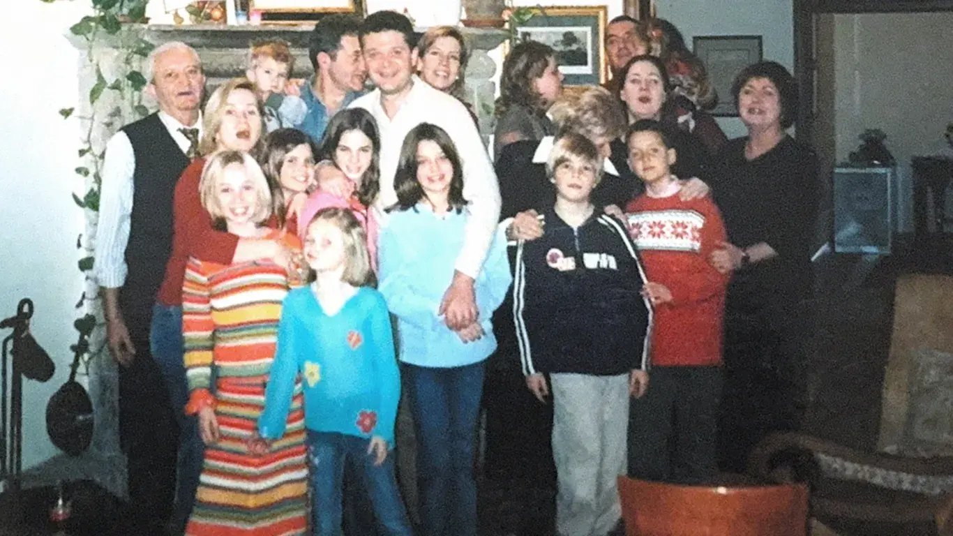 An archival photograph of the family gathered in a room, children at the front