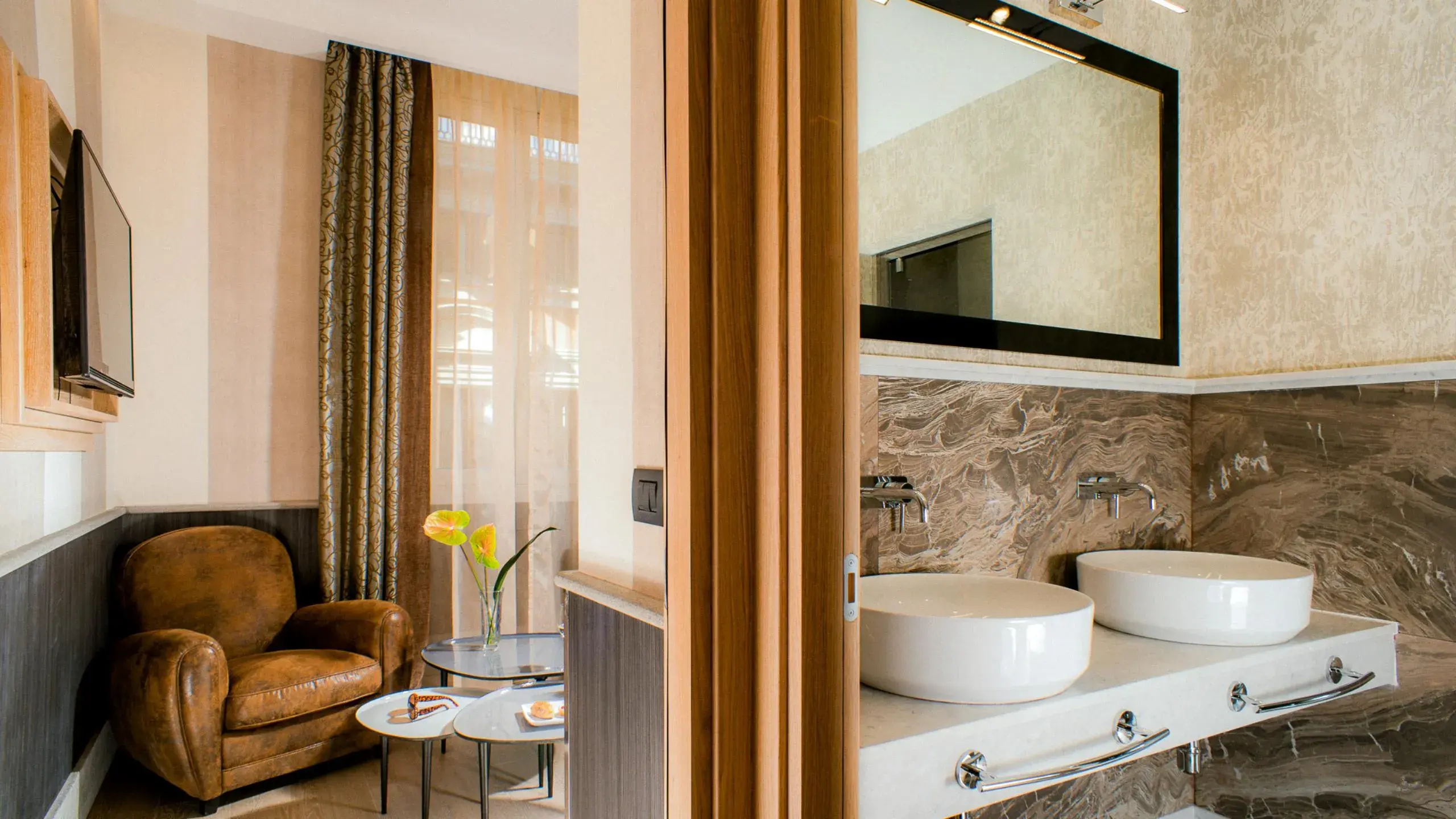 A room and its marble bathroom seen through a folding wooden door